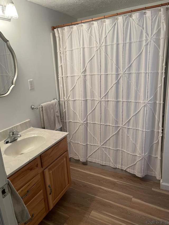 bathroom with vanity, hardwood / wood-style floors, a shower with curtain, and a textured ceiling