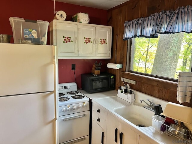 kitchen with sink, white appliances, and white cabinets