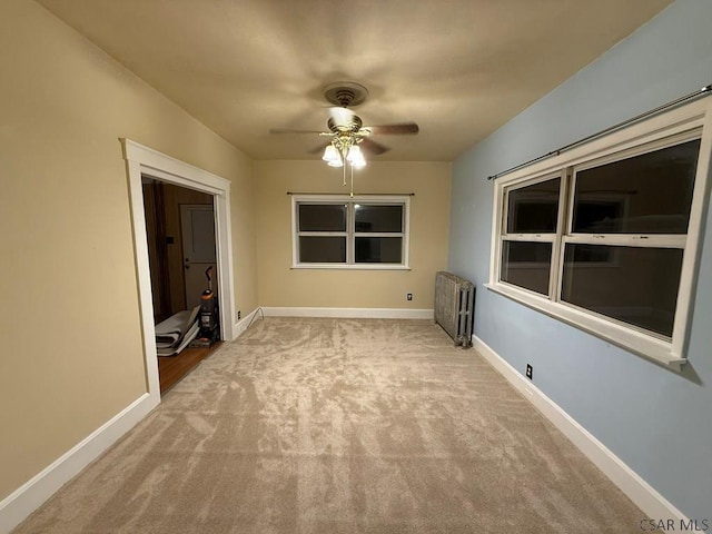 empty room with radiator, light colored carpet, and ceiling fan