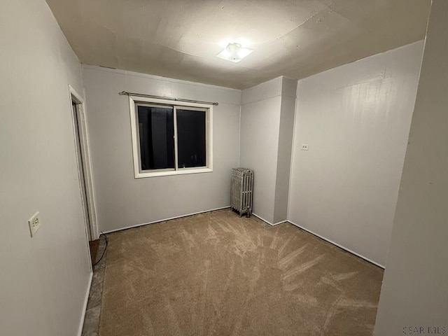 carpeted empty room with radiator heating unit