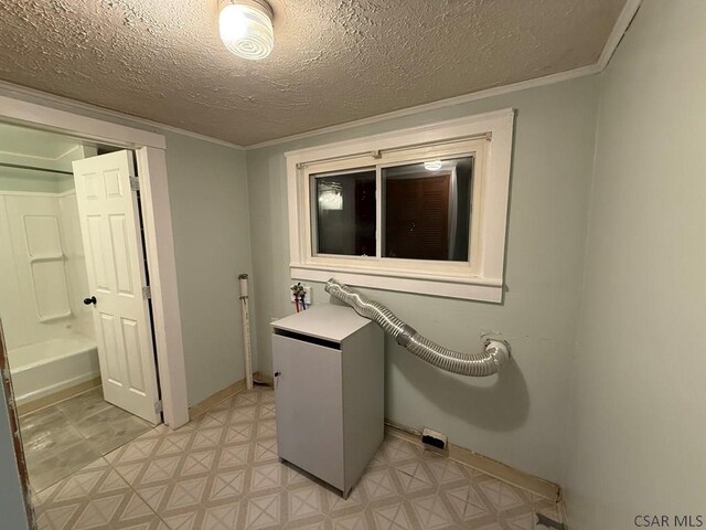 clothes washing area featuring ornamental molding and a textured ceiling