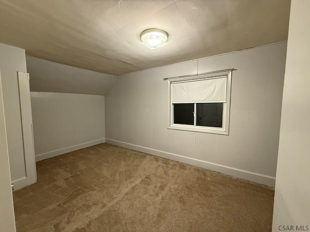 additional living space featuring vaulted ceiling and carpet floors