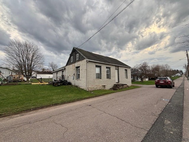 view of property exterior featuring a yard and brick siding