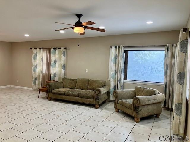 living room featuring light tile patterned flooring and ceiling fan