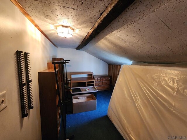 bedroom with vaulted ceiling with beams, ornamental molding, and dark colored carpet