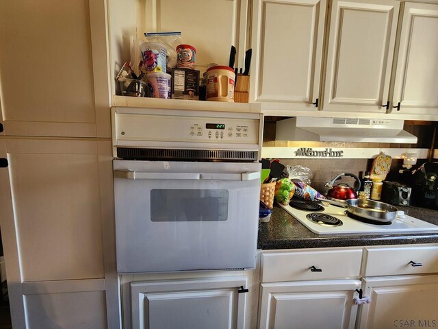 kitchen with ventilation hood, white appliances, and decorative backsplash