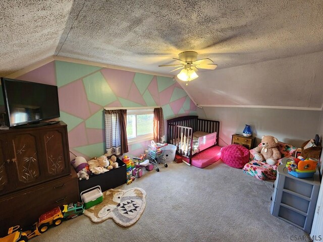 carpeted bedroom featuring vaulted ceiling, a nursery area, a textured ceiling, and ceiling fan