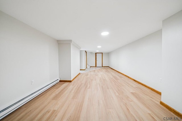 interior space with light wood finished floors, a baseboard radiator, baseboards, and recessed lighting