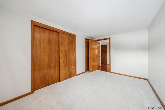 unfurnished bedroom featuring a closet, baseboards, and carpet flooring