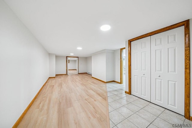 unfurnished room with baseboard heating, recessed lighting, light wood-style flooring, and baseboards