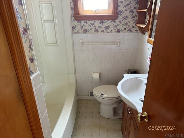 bathroom with vanity, a tub, tile walls, and toilet