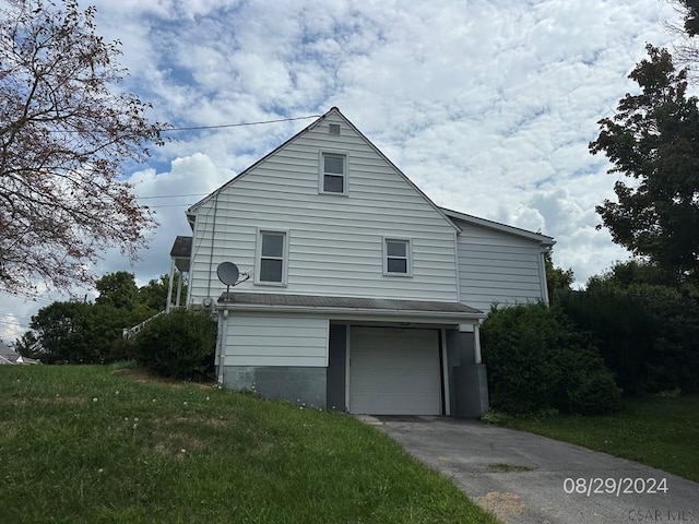 view of side of property featuring a garage and a yard