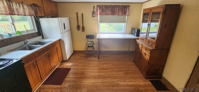 kitchen with sink, electric range, wood-type flooring, and white fridge