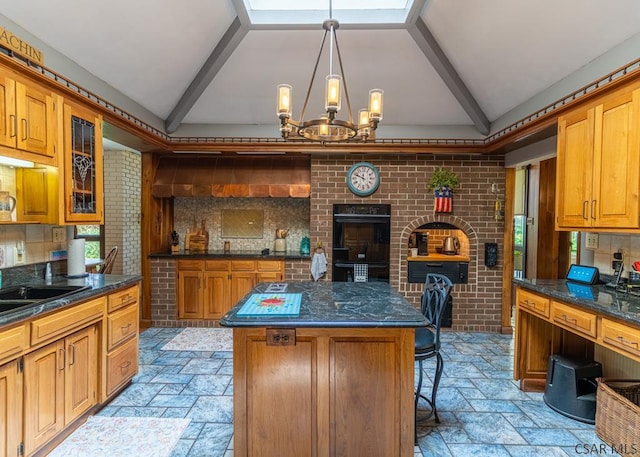 kitchen with a breakfast bar area, an inviting chandelier, hanging light fixtures, a kitchen island, and black double oven