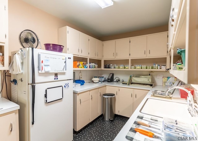 kitchen with cream cabinets and white fridge