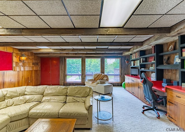 home office with built in desk, wooden walls, carpet, and a paneled ceiling