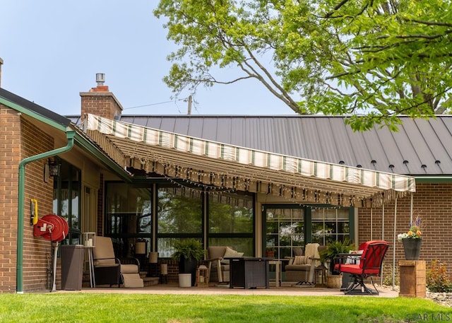 rear view of property featuring a patio and a lawn