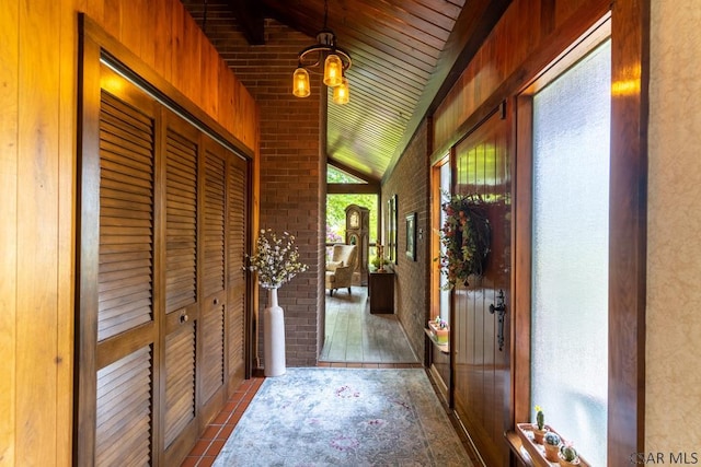 interior space featuring vaulted ceiling, brick wall, and wooden walls