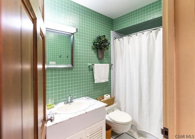 bathroom with tile walls, vanity, curtained shower, and toilet