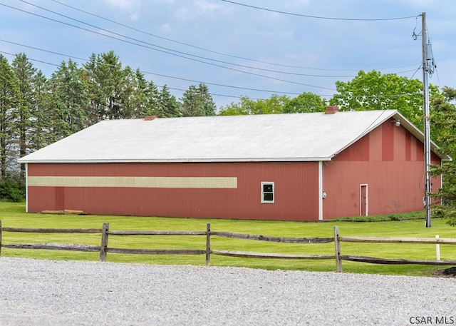 view of property exterior featuring an outbuilding and a lawn