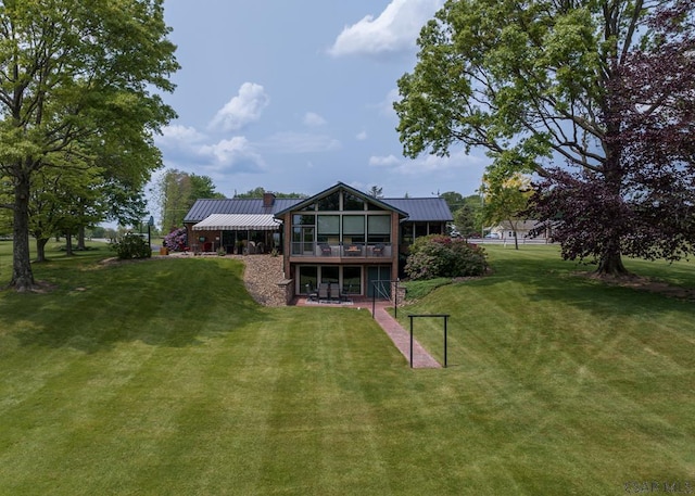 rear view of house featuring a yard