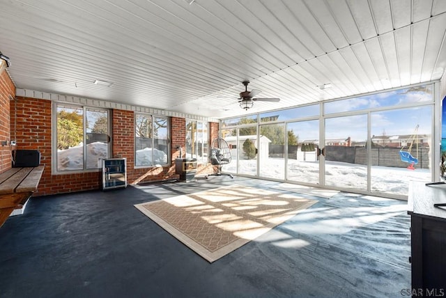 unfurnished sunroom with heating unit, a wealth of natural light, and ceiling fan