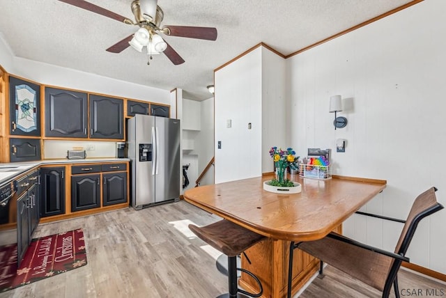 kitchen featuring crown molding, stainless steel fridge, ceiling fan, a textured ceiling, and light wood-type flooring