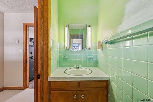 bathroom featuring vanity, tile walls, and a textured ceiling