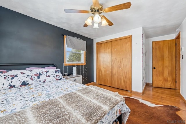 bedroom with ceiling fan, a closet, and light hardwood / wood-style flooring