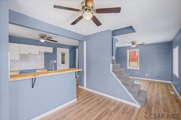 3445 Graham Ave, Windber, PA 15963 - kitchen featuring ceiling fan, white cabinetry, light wood-style flooring, wood counters, and a breakfast bar