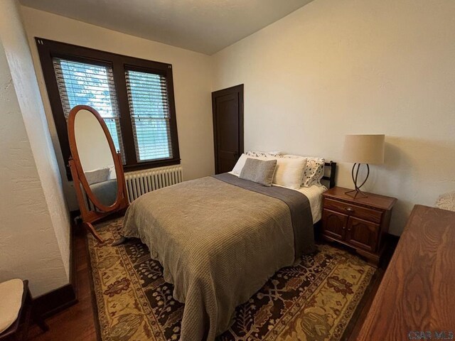 bedroom featuring radiator and dark wood-type flooring