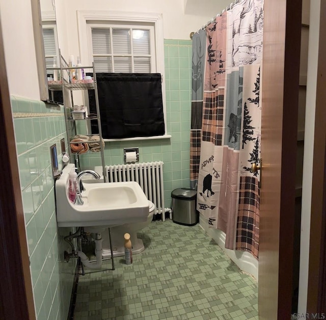 bathroom with radiator heating unit, shower / tub combo, and tile walls