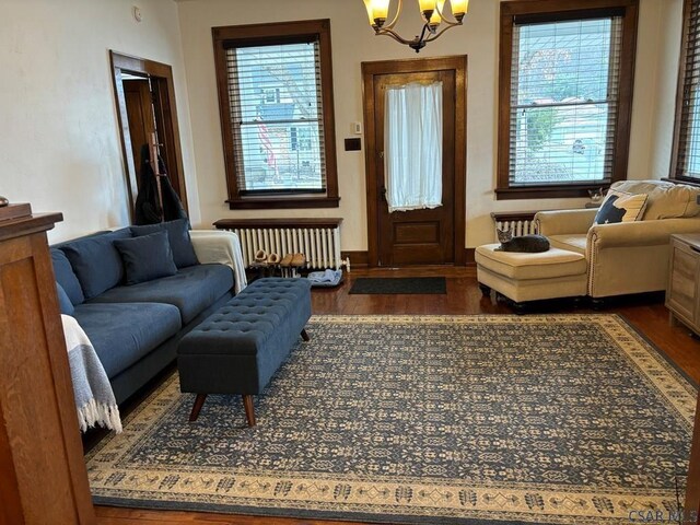 interior space featuring dark hardwood / wood-style floors, radiator heating unit, and a chandelier