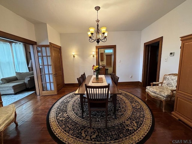 dining room featuring dark hardwood / wood-style floors and a chandelier