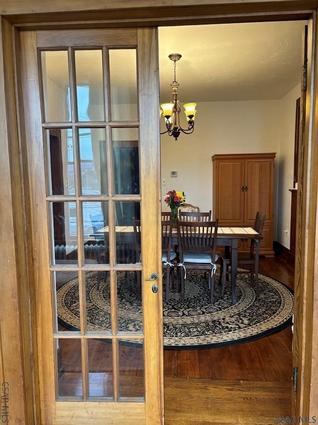 dining area with hardwood / wood-style floors and a chandelier