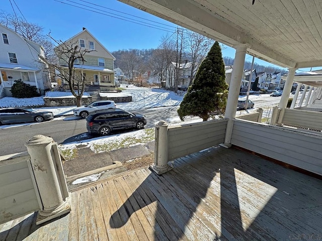 snow covered deck featuring a porch