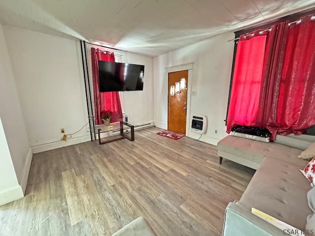 unfurnished living room with heating unit and hardwood / wood-style floors