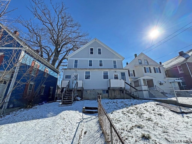 view of snow covered back of property