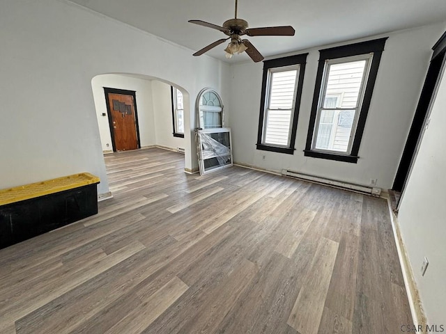 spare room with hardwood / wood-style floors, ceiling fan, and a baseboard heating unit