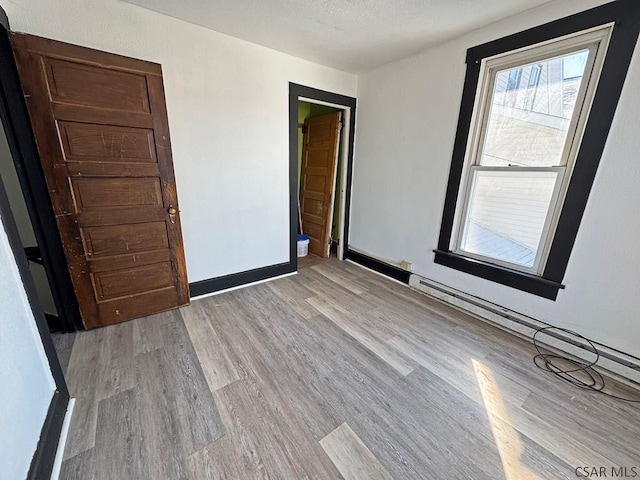 empty room featuring a textured ceiling and light hardwood / wood-style floors