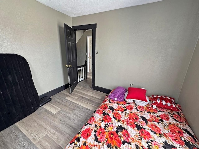 bedroom with light hardwood / wood-style floors and a textured ceiling