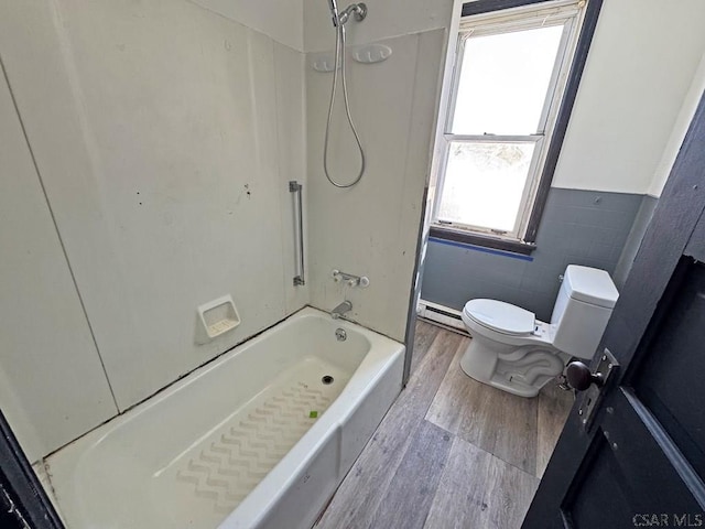 bathroom with toilet, wood-type flooring, bathtub / shower combination, tile walls, and a baseboard heating unit