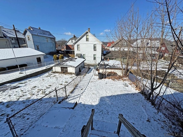 view of snow covered back of property