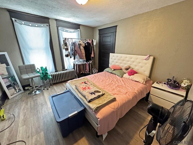 bedroom with hardwood / wood-style floors and a textured ceiling