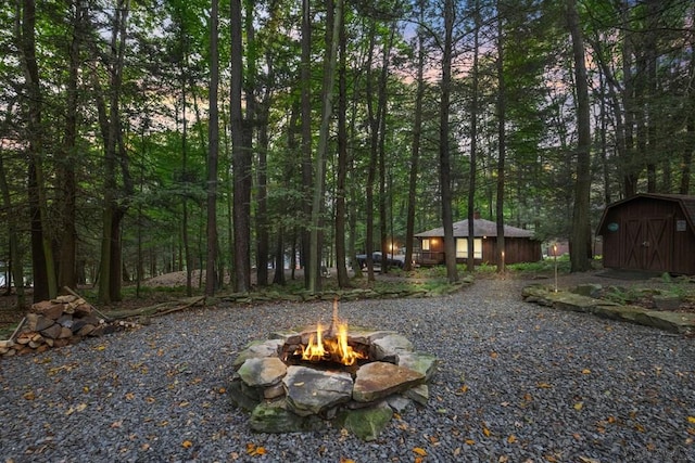 view of yard with an outdoor fire pit and a storage unit