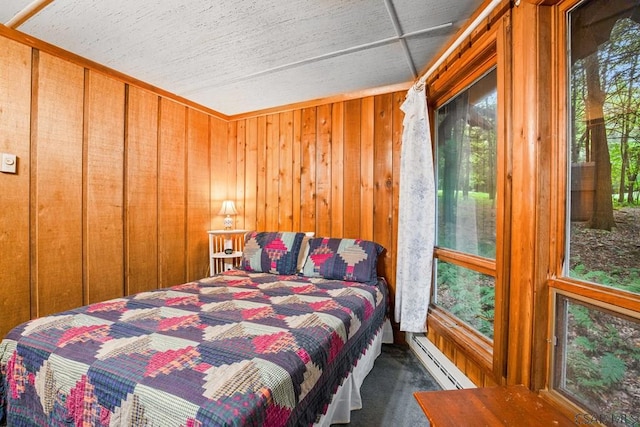 bedroom featuring a baseboard radiator, wooden walls, and carpet flooring