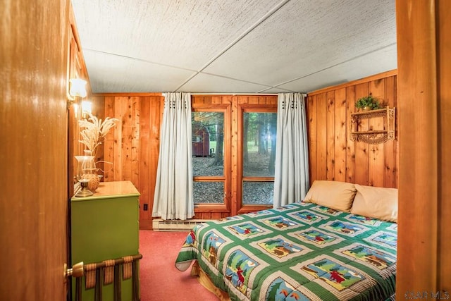 bedroom with a baseboard heating unit, carpet flooring, and wooden walls