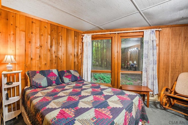 carpeted bedroom featuring wooden walls and a baseboard radiator