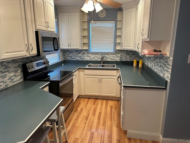 kitchen featuring backsplash, stainless steel appliances, sink, and white cabinets