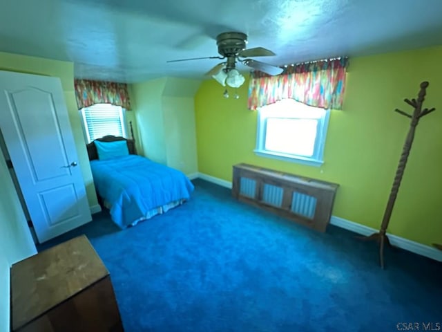 bedroom with dark colored carpet, radiator heating unit, and ceiling fan